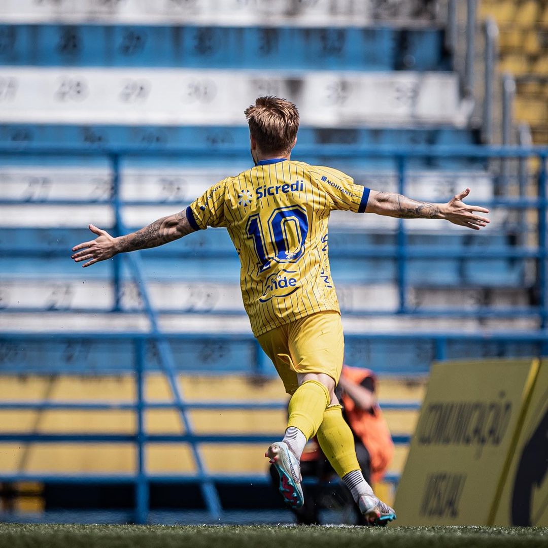 Nicholas, meia do São José, comemorando gol de braços abertos