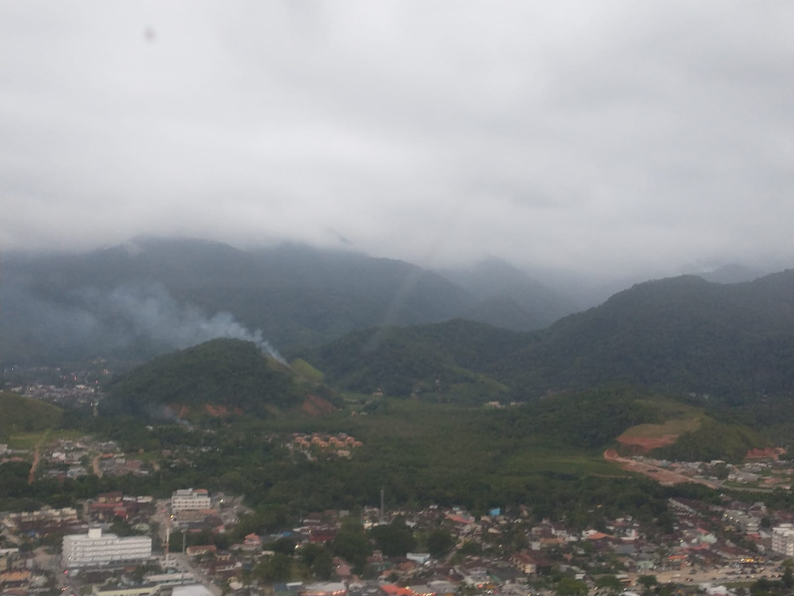 Vista panoramica de região de buscas por helicóptero desaparecido no Litoral Norte de SP; famílias contratam mateiros