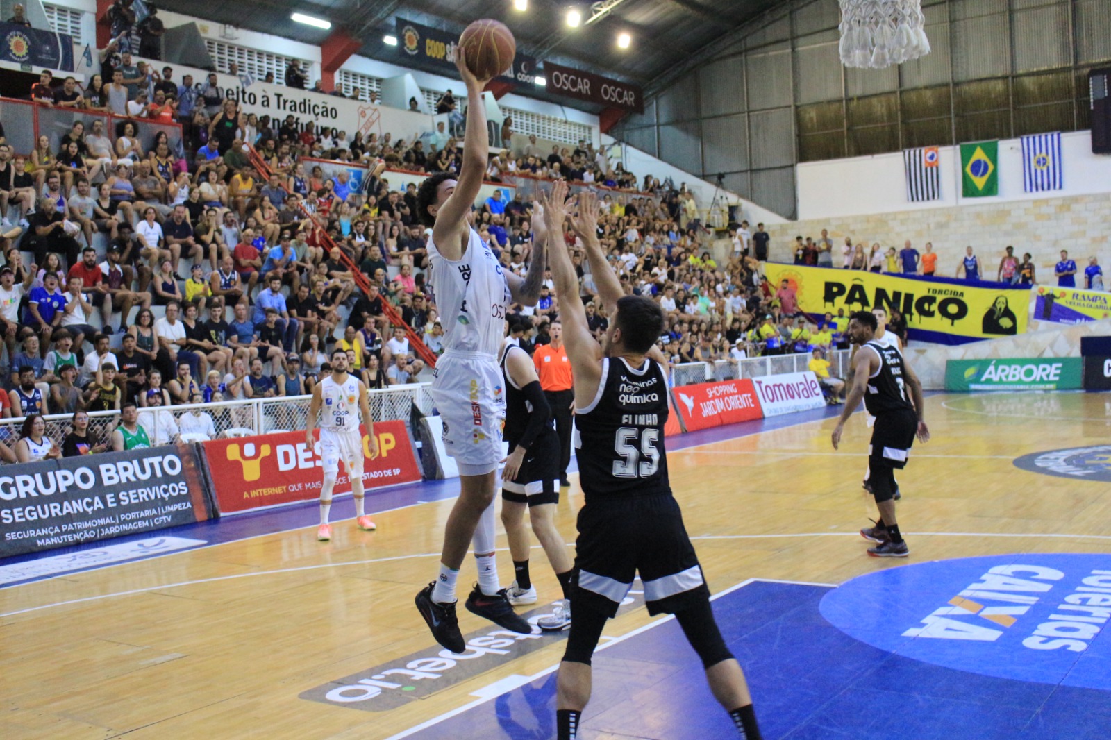 atleta do são josé basketball arremessando bola contra a defesa do corinthians no NBB