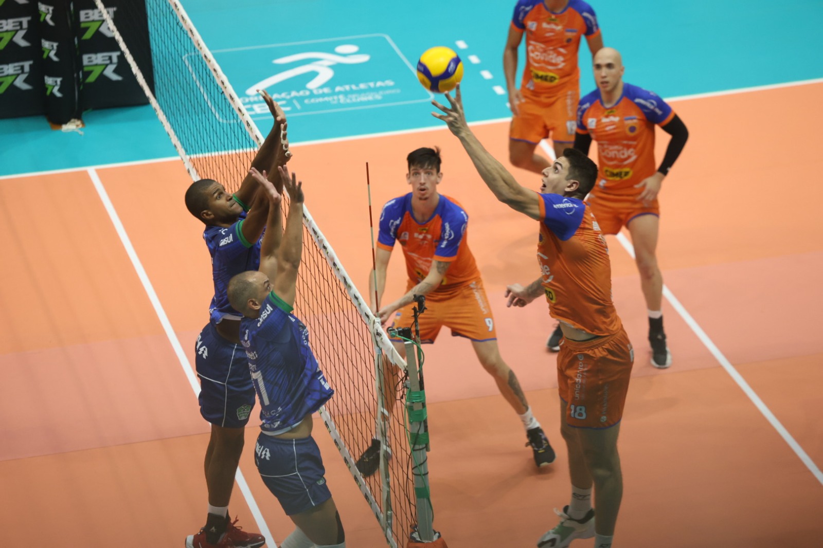 Atleta do Vôlei São José atacando a bola contra bloqueio adversário durante partida da superliga