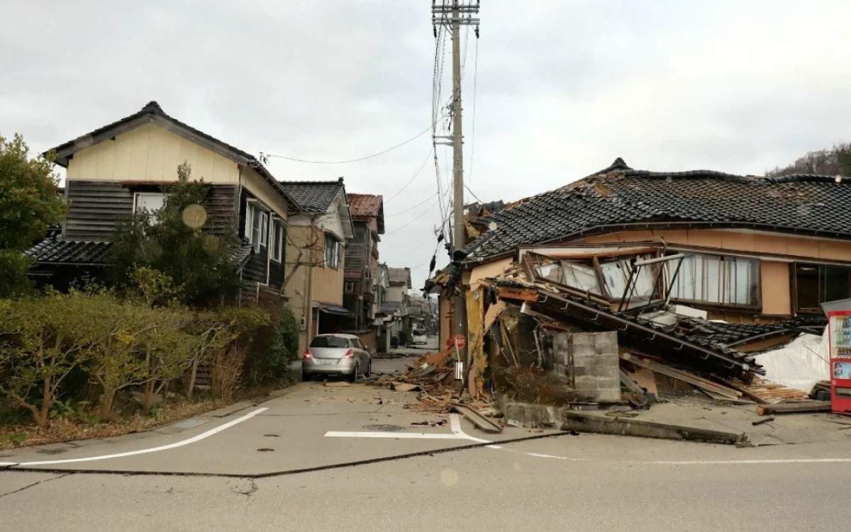 rua residencial no japão com asfalto danificado, levantado pelo terremoto, e casas destruídas