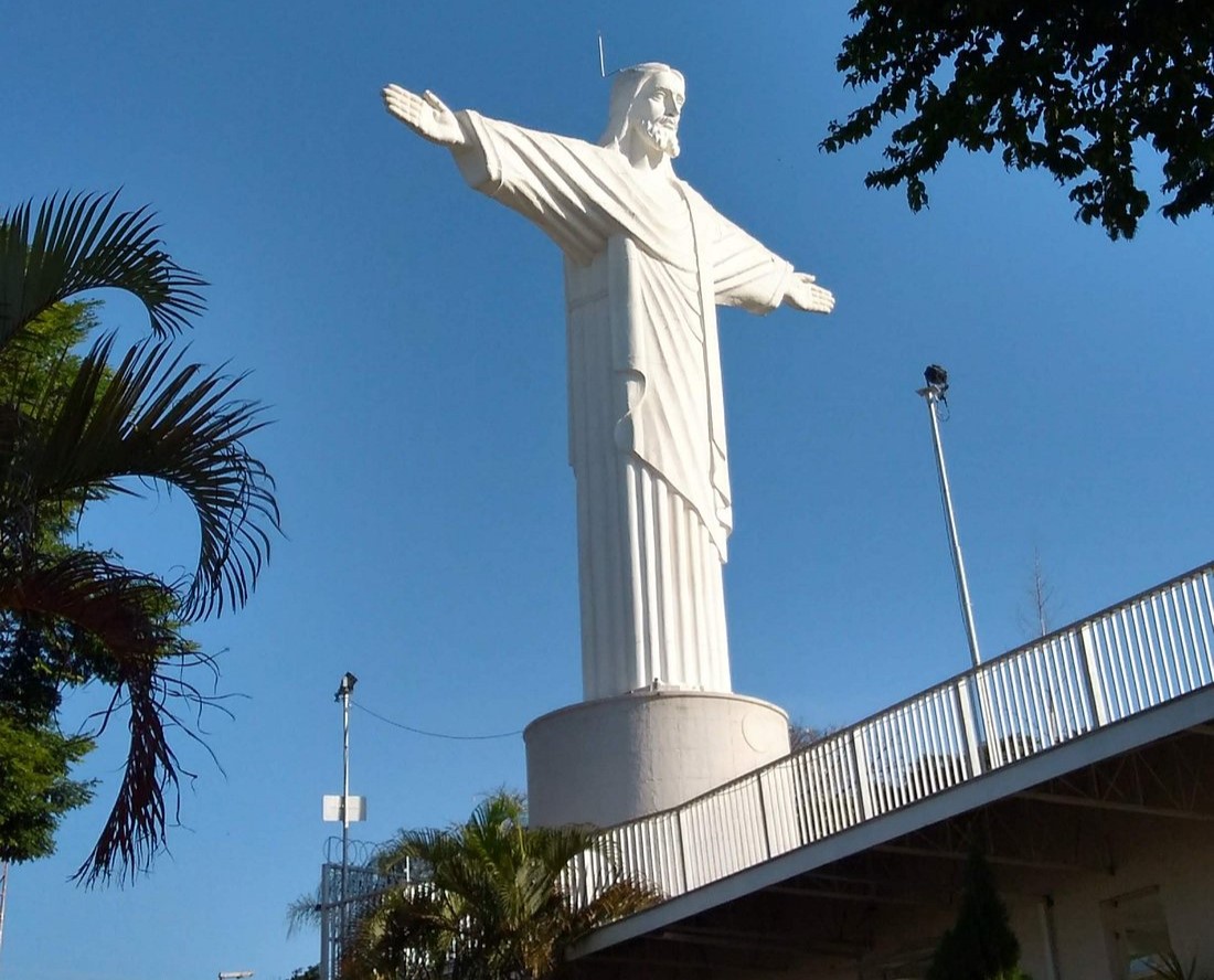 cristo redentor de taubaté visto de lado em dia de sol com céu azul