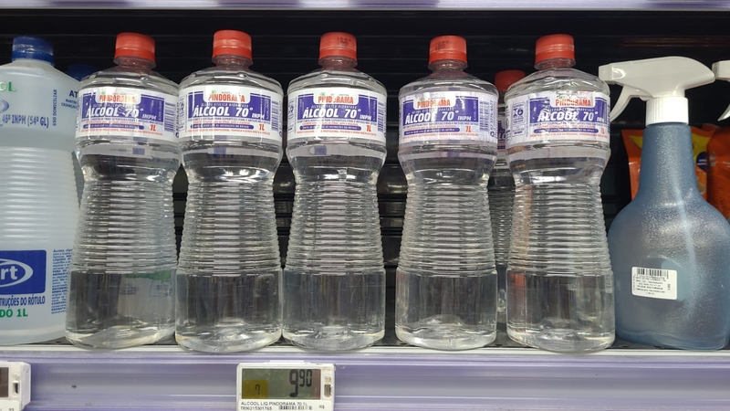 embalagens de álcool 70% líquido exibidas em prateleira de mercad