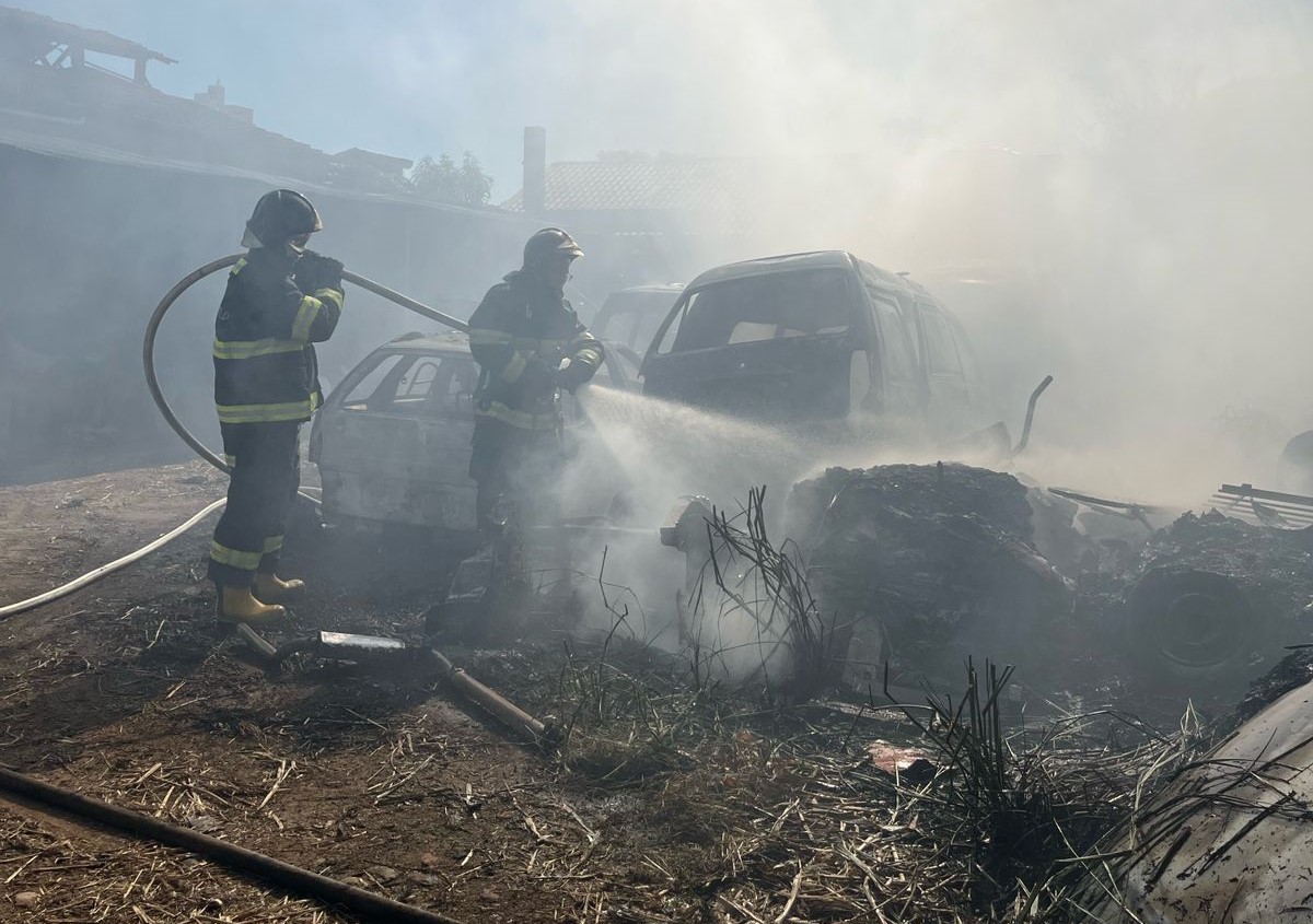 bombeiros no meio de muita fumaça enquanto controlam incêndio em oficina