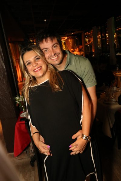Casal abraçado de pé durante jantar do Dia dos Namorados no Amicci em SJC