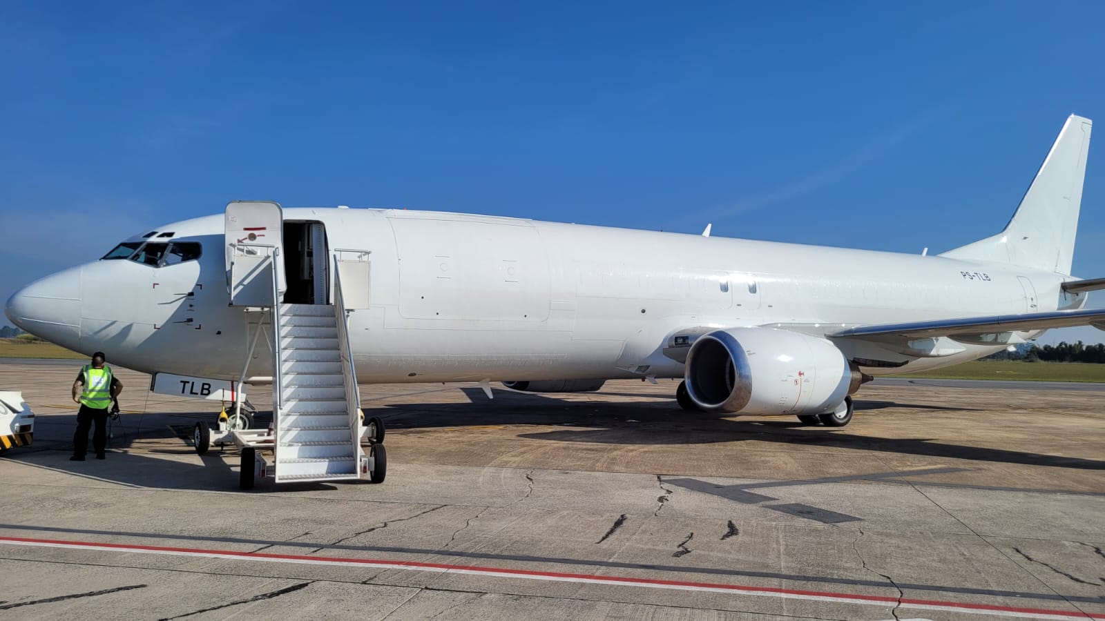 avião da boeing todo em branco, sem adesivagem, estacionado no aeroporto de são josé dos campos em tarde ensolarada e de céu azul