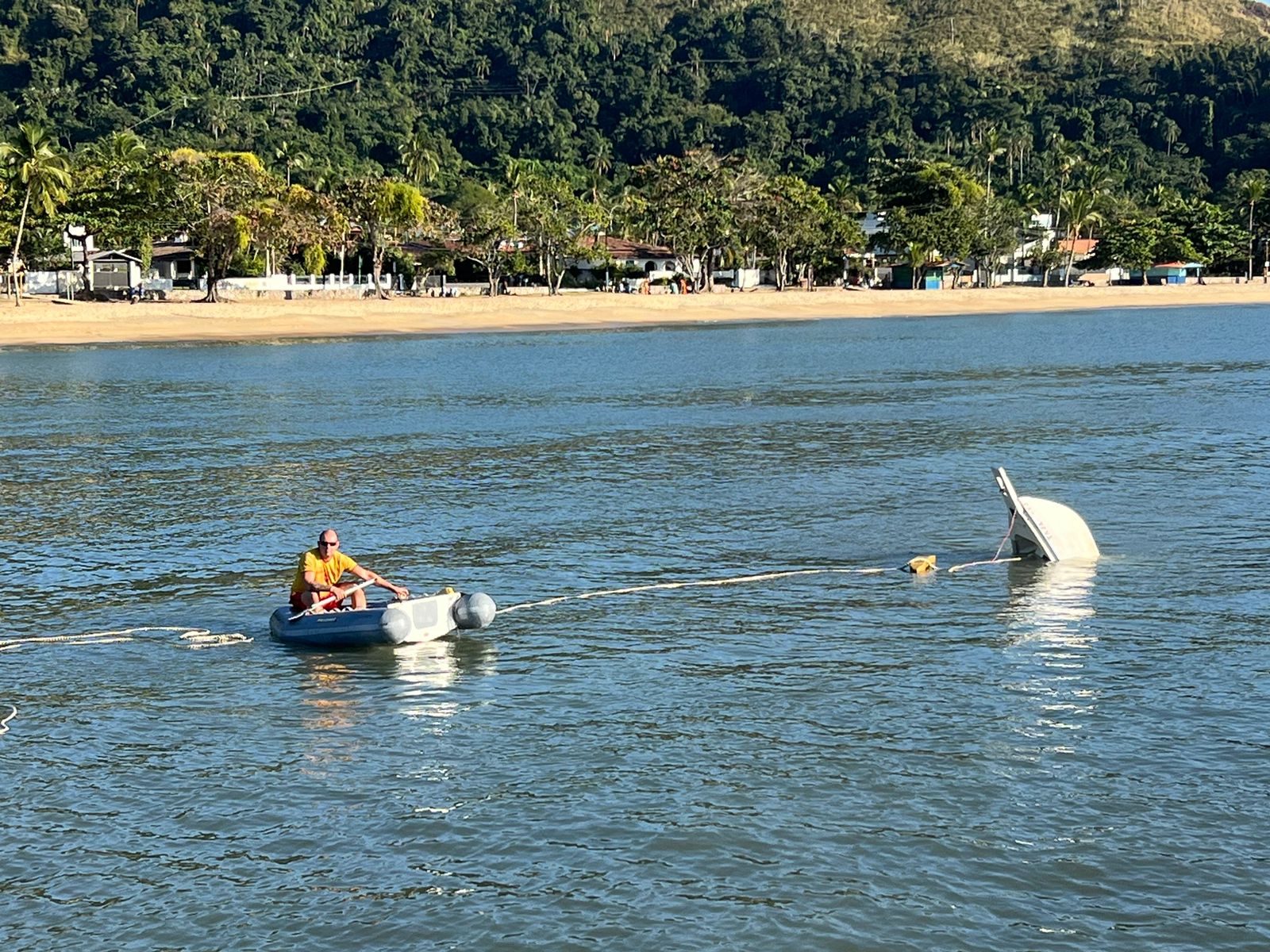 Bombeiro procurando por pescador desaparecido após barco virar no mar em São Sebastião
