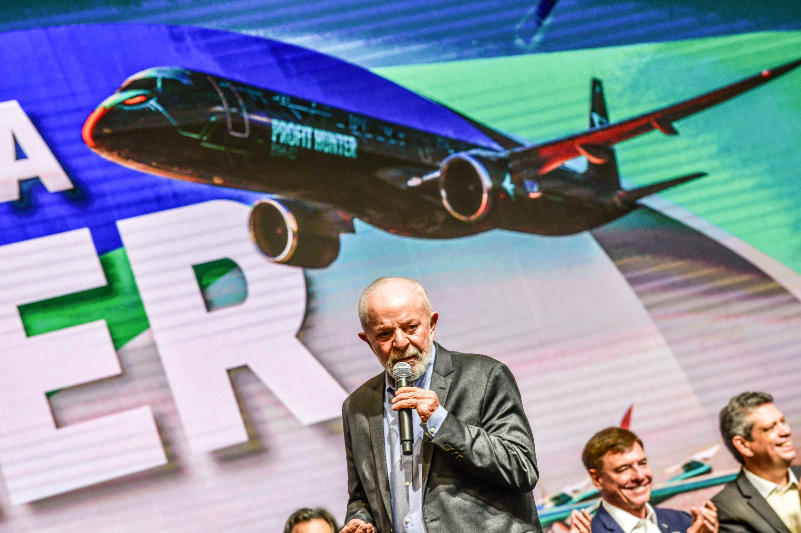 Lula falando em microfone durante vista à Embraer, em São José