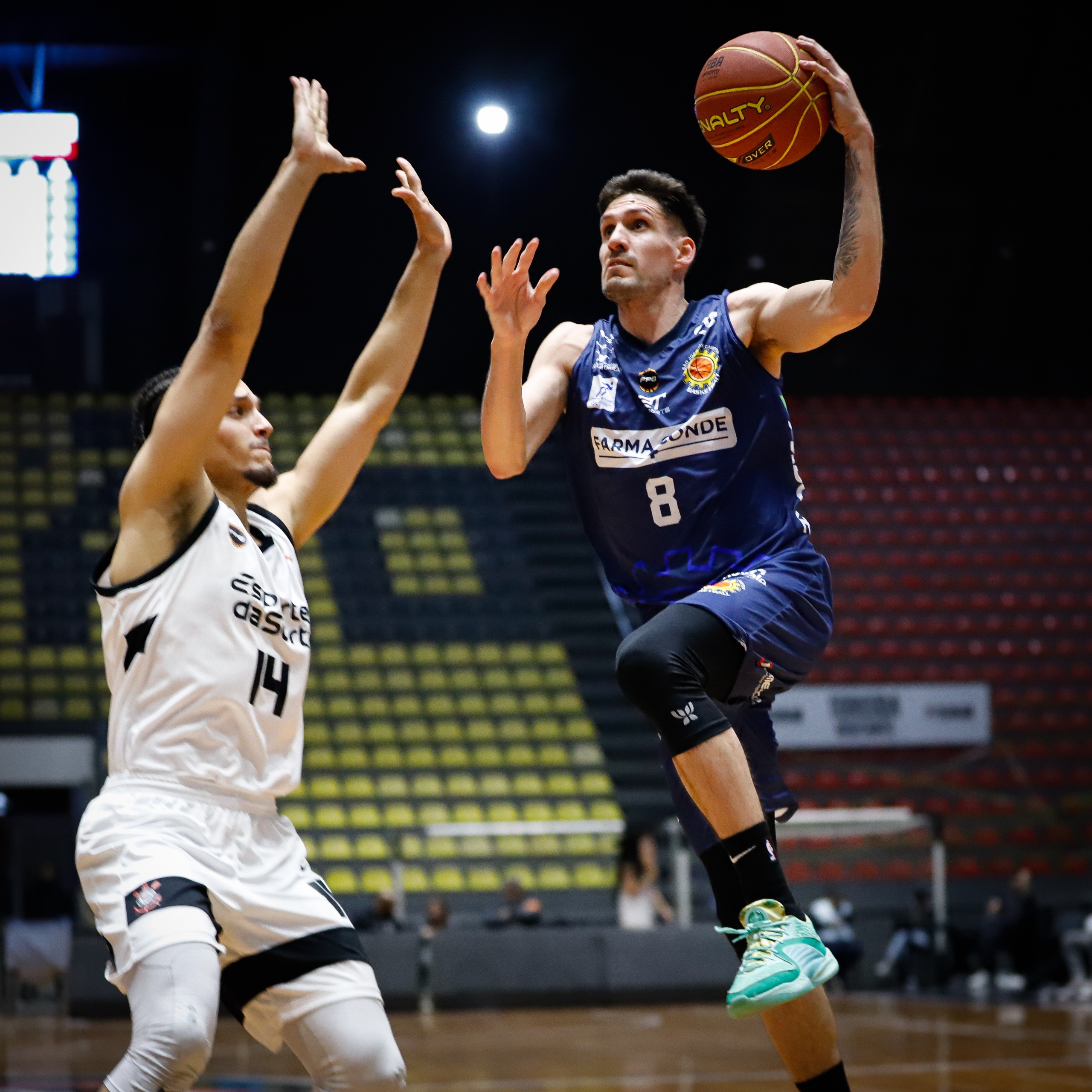 Atleta do São José Basketball conduzindo a bola contra defesa do Corinthians