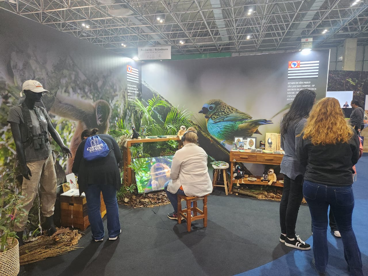 Estande de São José e São Francisco Xavier com exposição sobre aves e muriquis