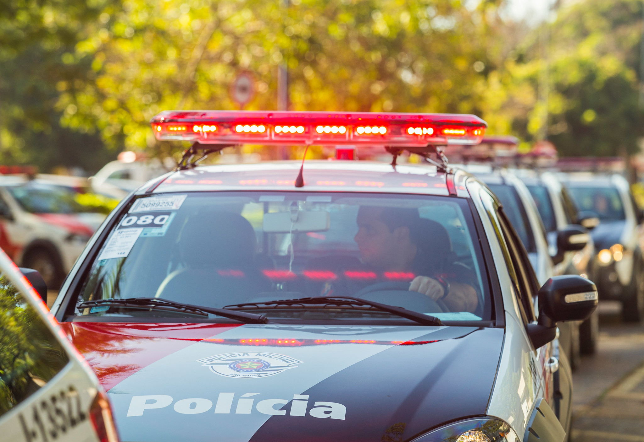 policial dirigindo viatura com sirene ligada