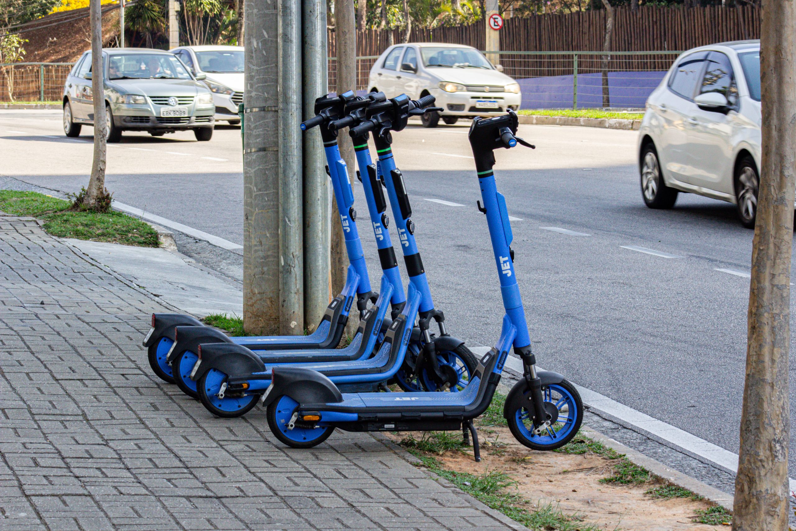patinetes em sjc estacionados em calçada de avenida movimentada