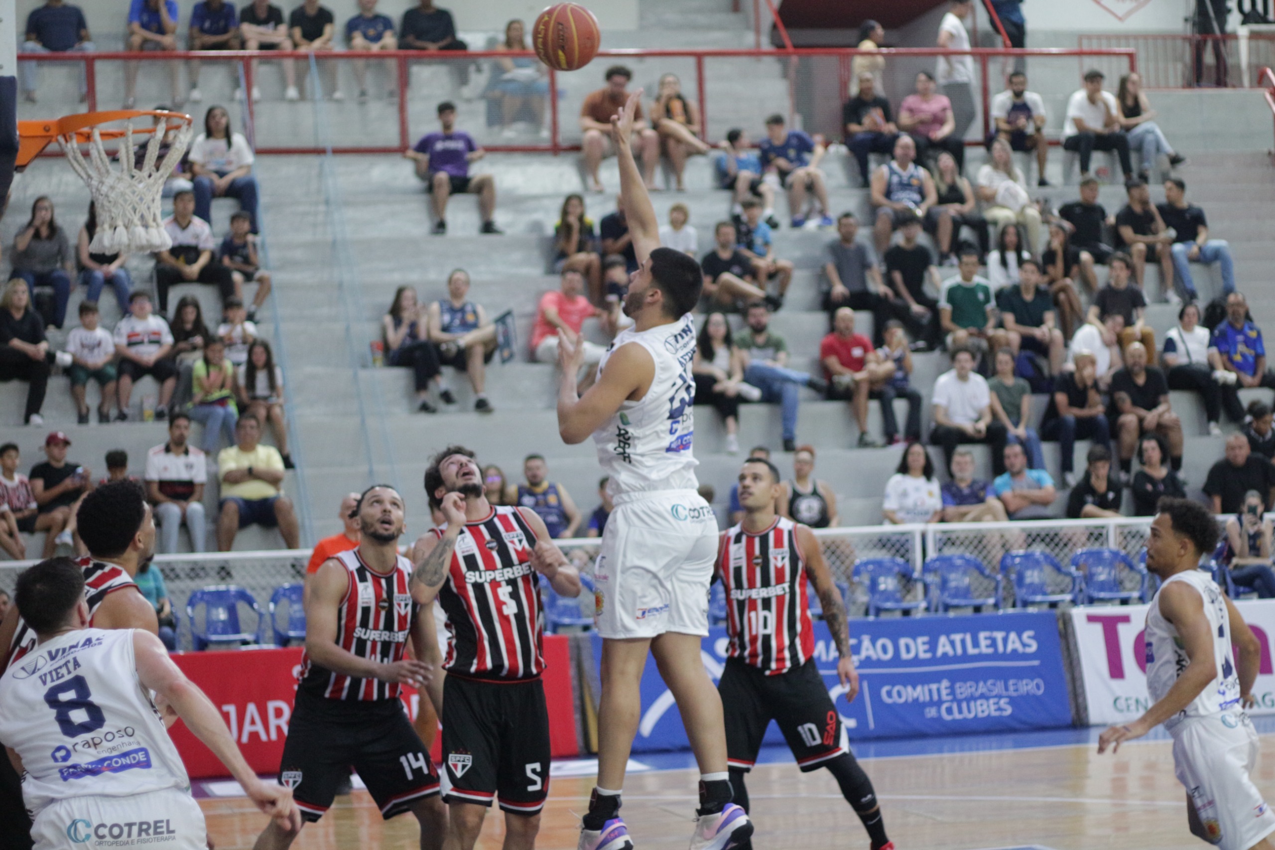 Jogador do São José Basketball jogando bola na cesta, em partida contra o São Paulo