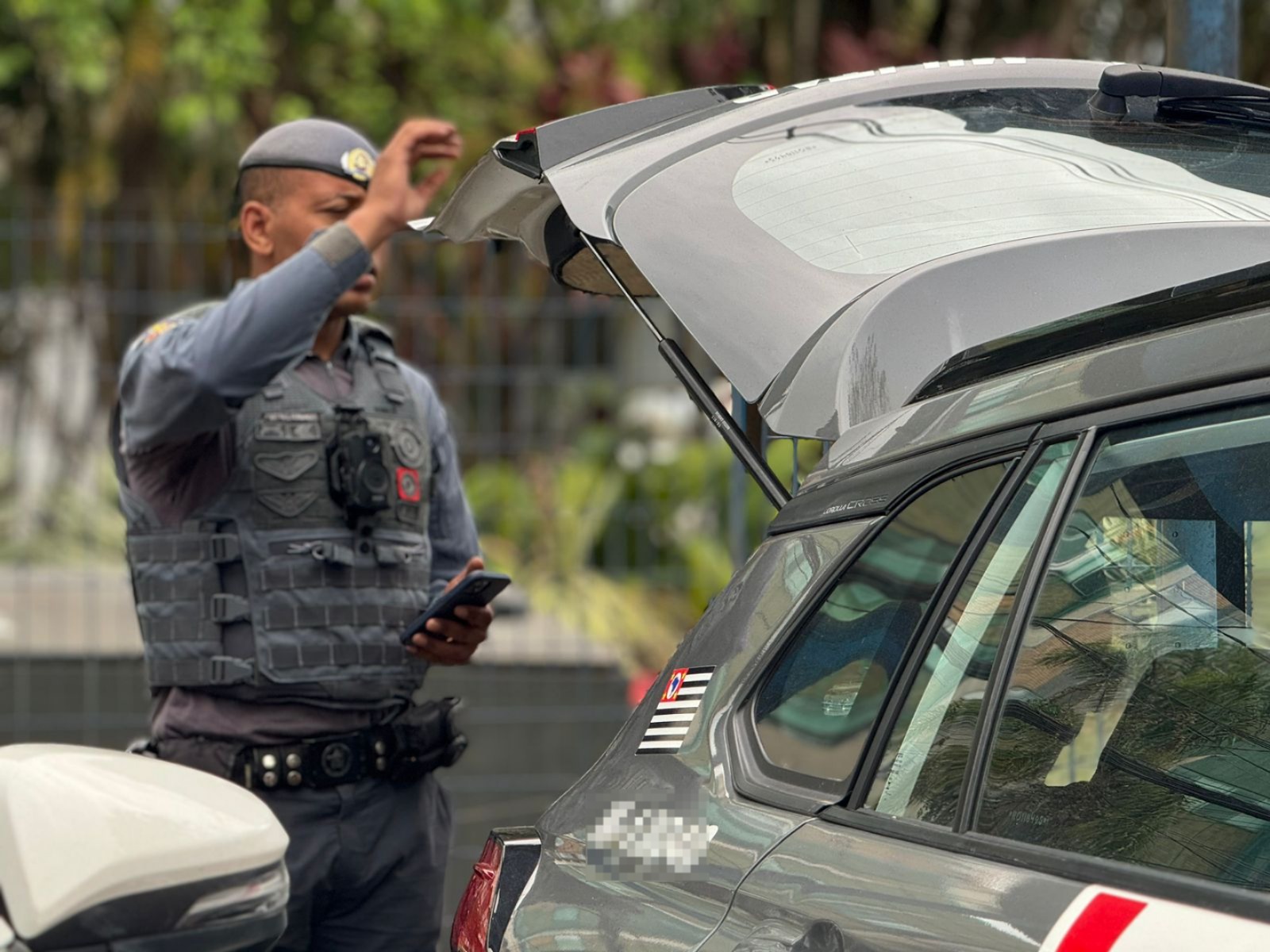 policial militar abrindo porta-malas de viatura