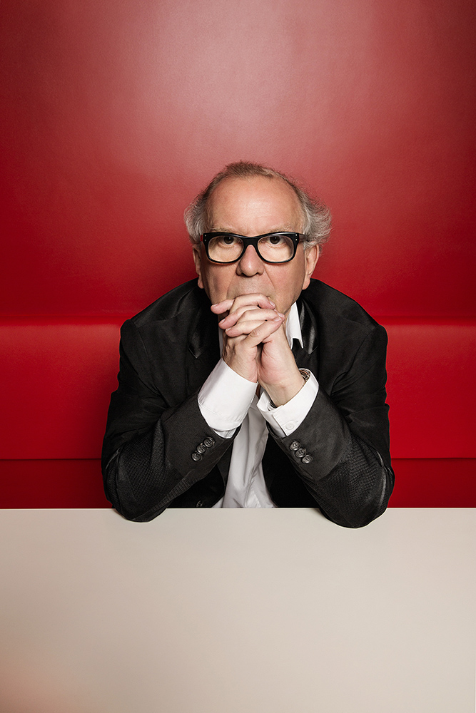 washington olivetto apoiado com os cotovelos sobre bancada e as mãos dadas tapando a boca
