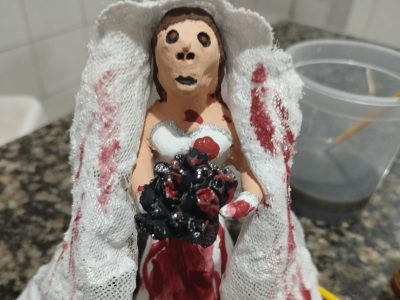figura de barro de noiva ensanguentada com buquê de tripas