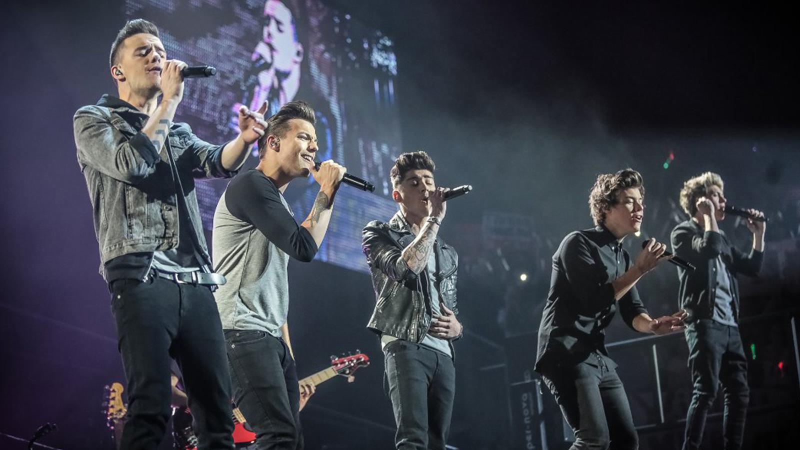 cantores da banda one direction em palco durante turnê