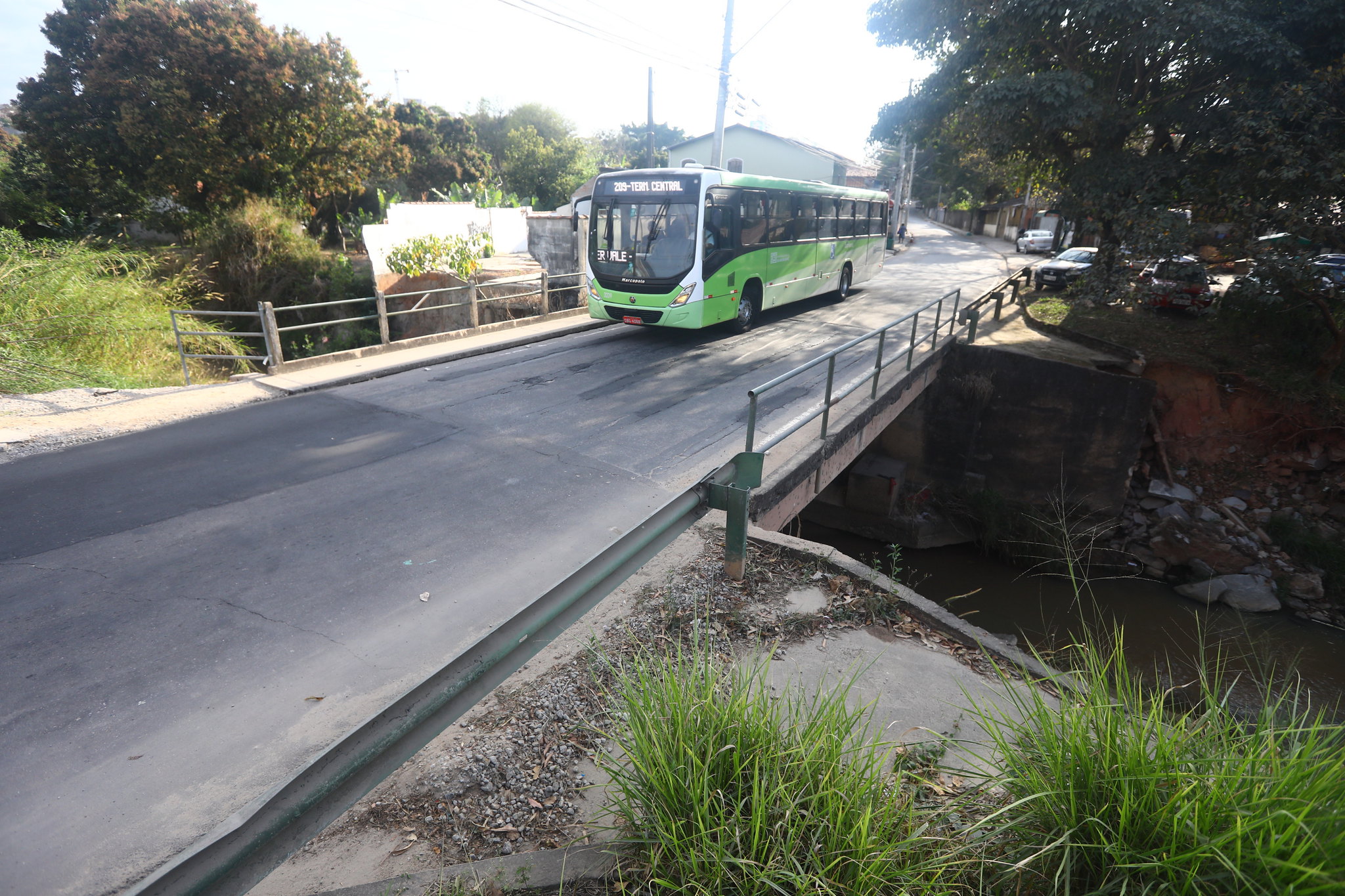 Ônibus passando sobre córrego em avenida