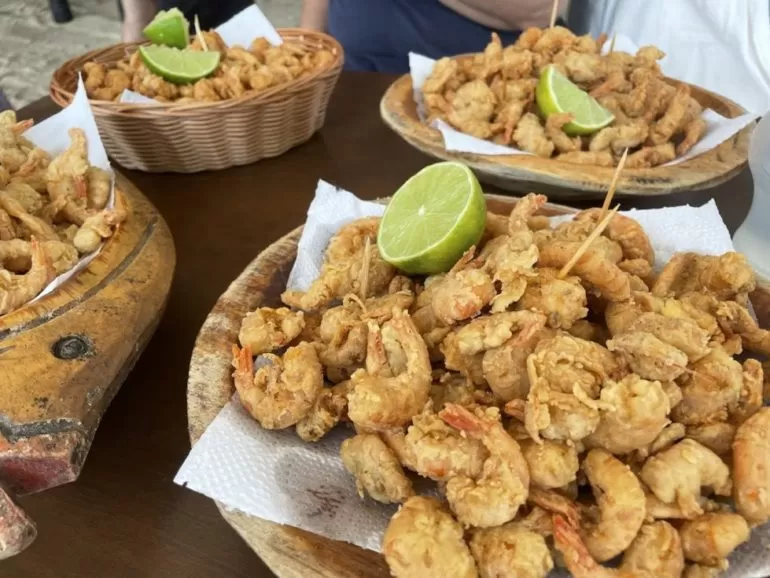 Tábuas e cestas com camarões fritos