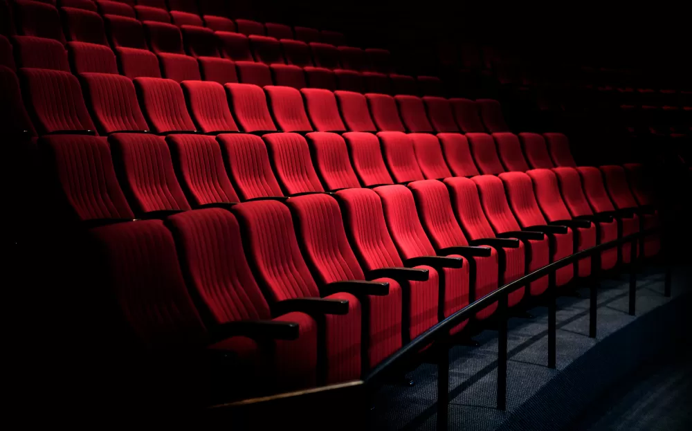 Poltronas de cinema nas cores vermelha, no escuro, ilustrando a lista de cinemas em sjc.