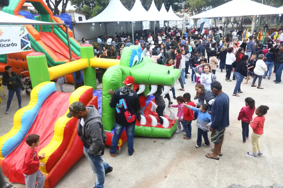 Público presente em edição do Conexão Juventude. É possível ver toldos brancos, brinquedos infláveis e um grande número de presentes.