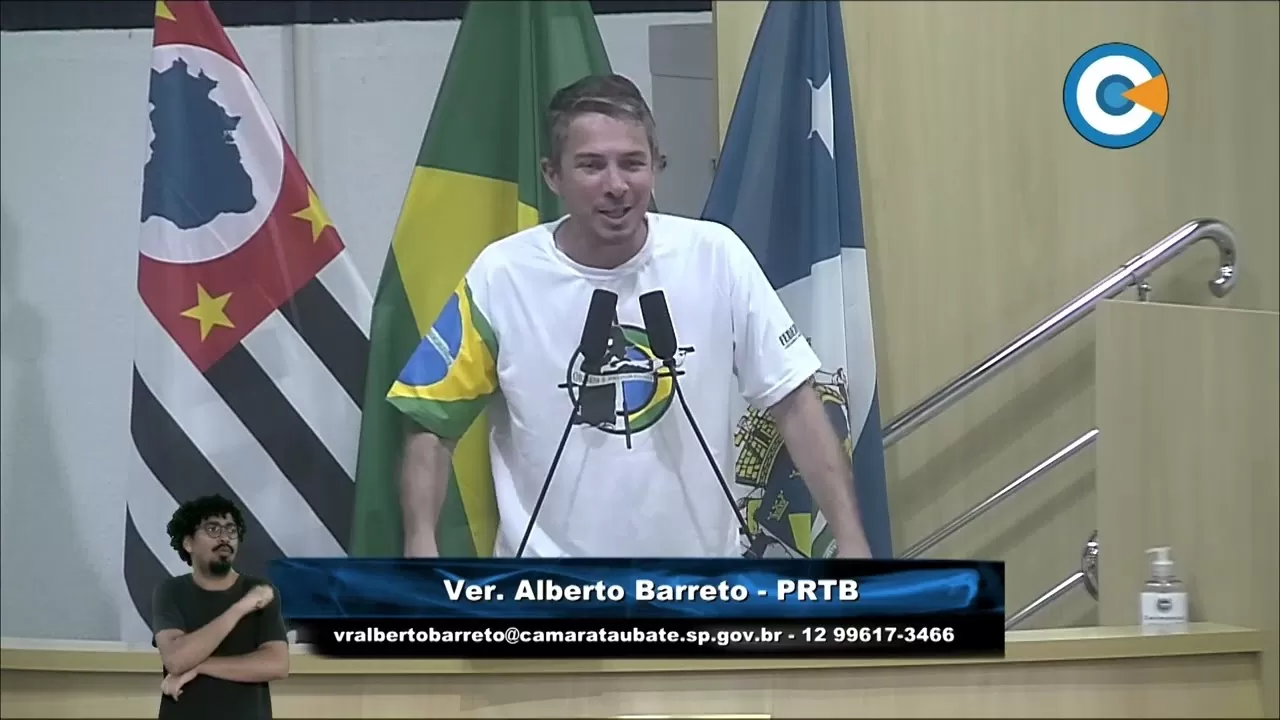 Alberto Barreto com camiseta branca e bandeiras do Brasil, SP e Taubaté.