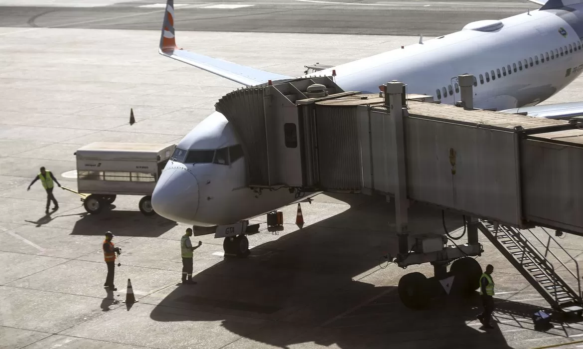 Foto mostra um avião estacionado, com pessoas em volta, ilustrando a matéria que fala que a Petrobras eleva preço de querosene de aviação em 7,3%.