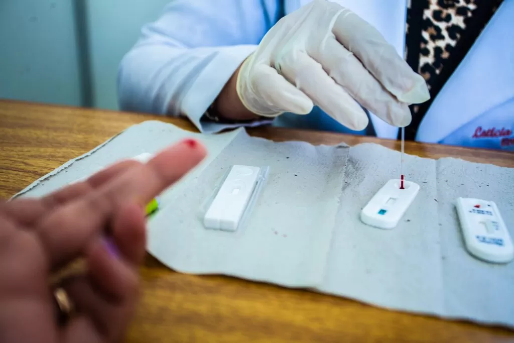 profissional de saúde realizando teste de hiv/sífilis em paciente