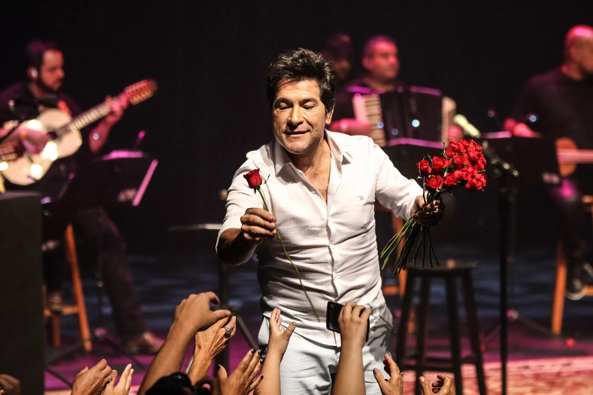 cantor daniela distribuind rosas durante apresentação. ele vai fazer show em são josé dos campos em fevereiro.