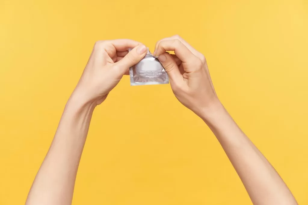 imagem ilustrativa de uma pessoa abrindo um pacote de preservativo; foto ilustra matéria de lotes suspensos da venda do preservatico blowtex
