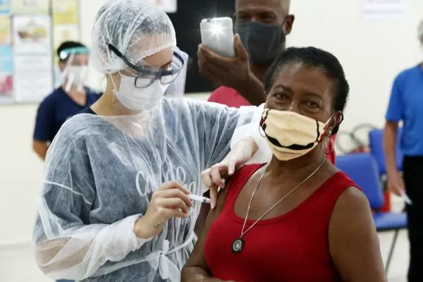 profissional da saúde vacinando mulher