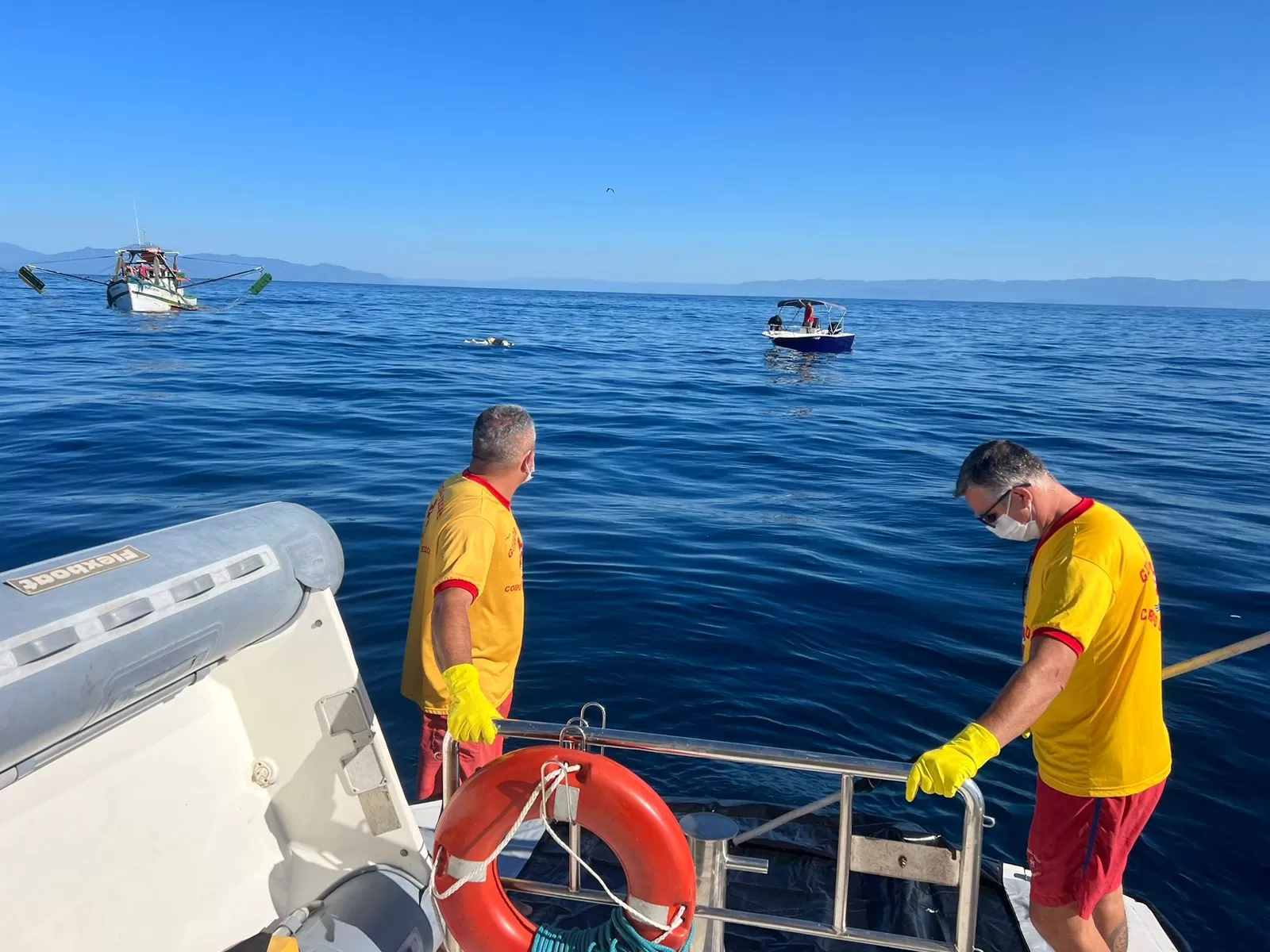 Dois bombeiros em uma lancha em alto mar na região da Ilha Vitória em Ubatuba