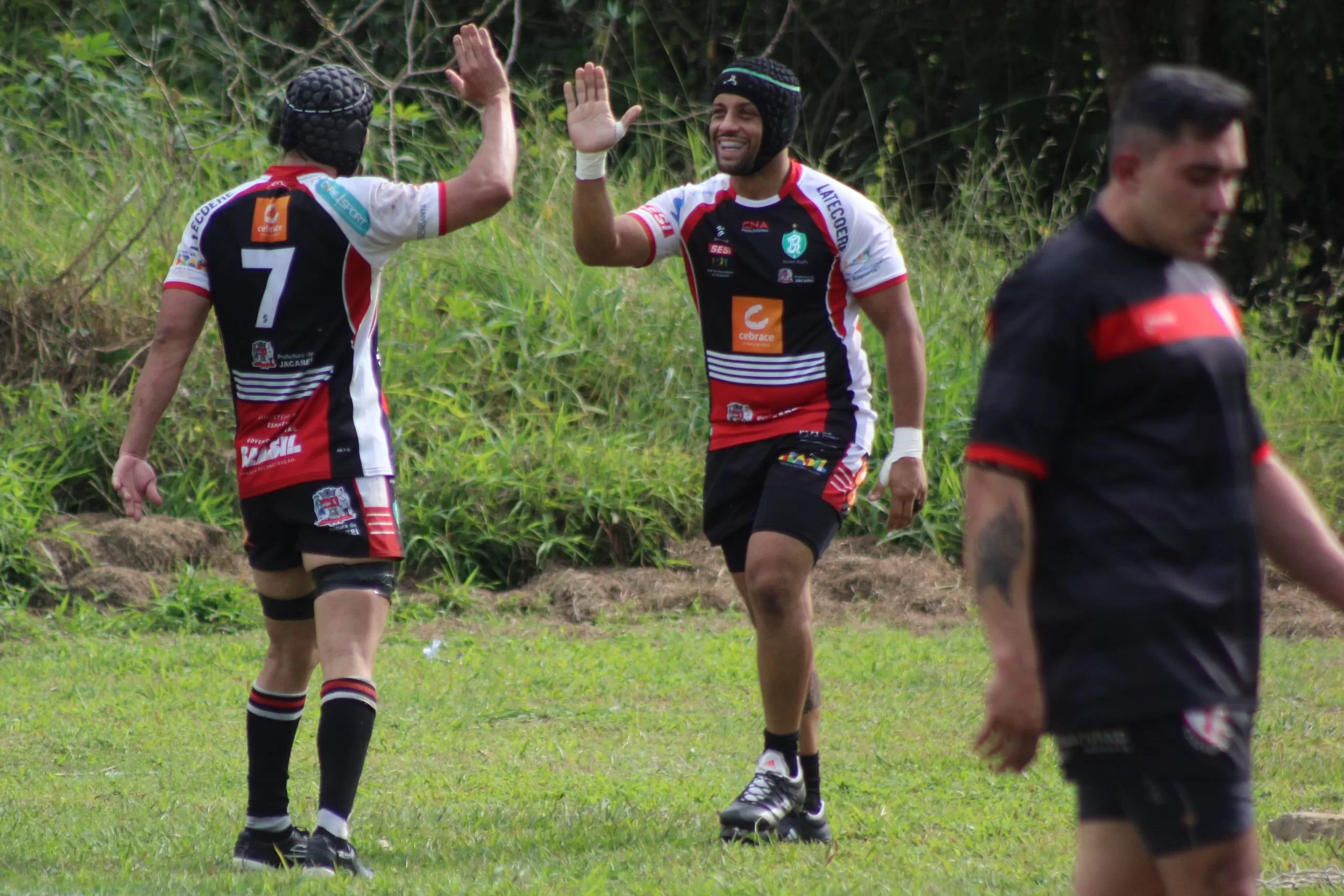 Jogadores do Jacareí Rugby comemorando, em dupla, batendo as mãos. O jogo entre São José e Jacareí Rugby acontecerá neste sábado.