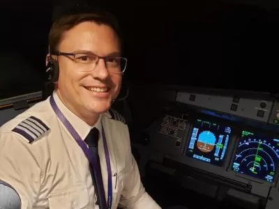 piloto angelo silva de farda na cabine de avião em viagem à noite