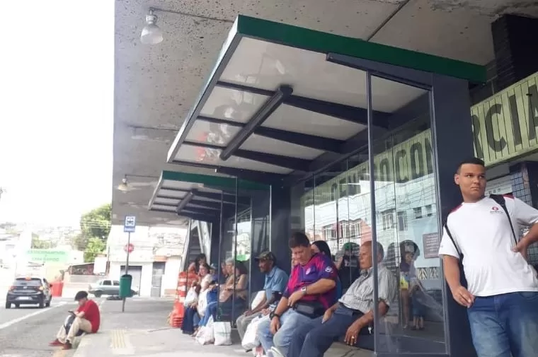 usuários do transporte público aguardando em ponto de ônibus coberto na antiga rodoviária de jacareí abaixo de marquise do terminal.