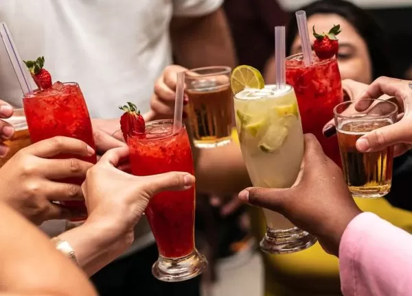 mãos brindando com caipirinhas no espetinho do papai
