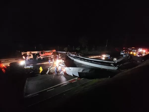 equipes trabalhando durante a noite para remoção do portal de entrada de pindamonhangaba, derrubado e destruído pelas chuvas