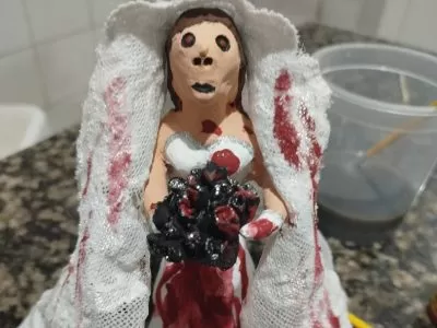figura de barro de noiva ensanguentada com buquê de tripas